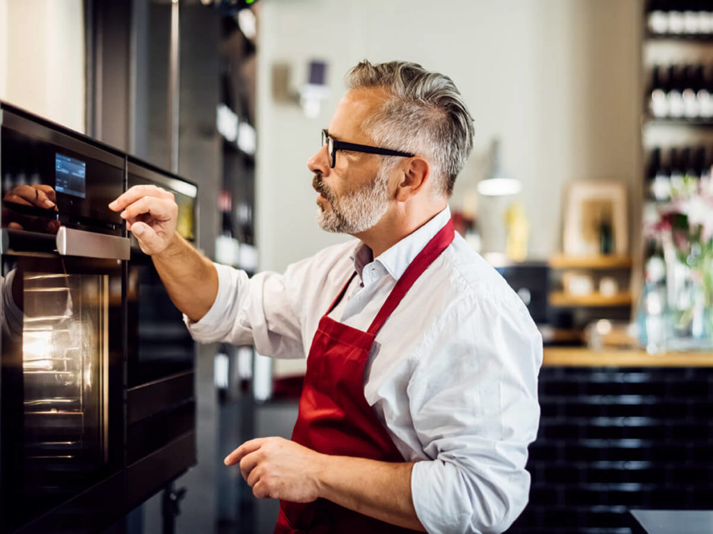 PHT Systems employee operating a Fri-Jado oven