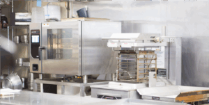 Foodservice equipment, like Henny Penny combi oven and a Henny Penny fyrer, in a kitchen.